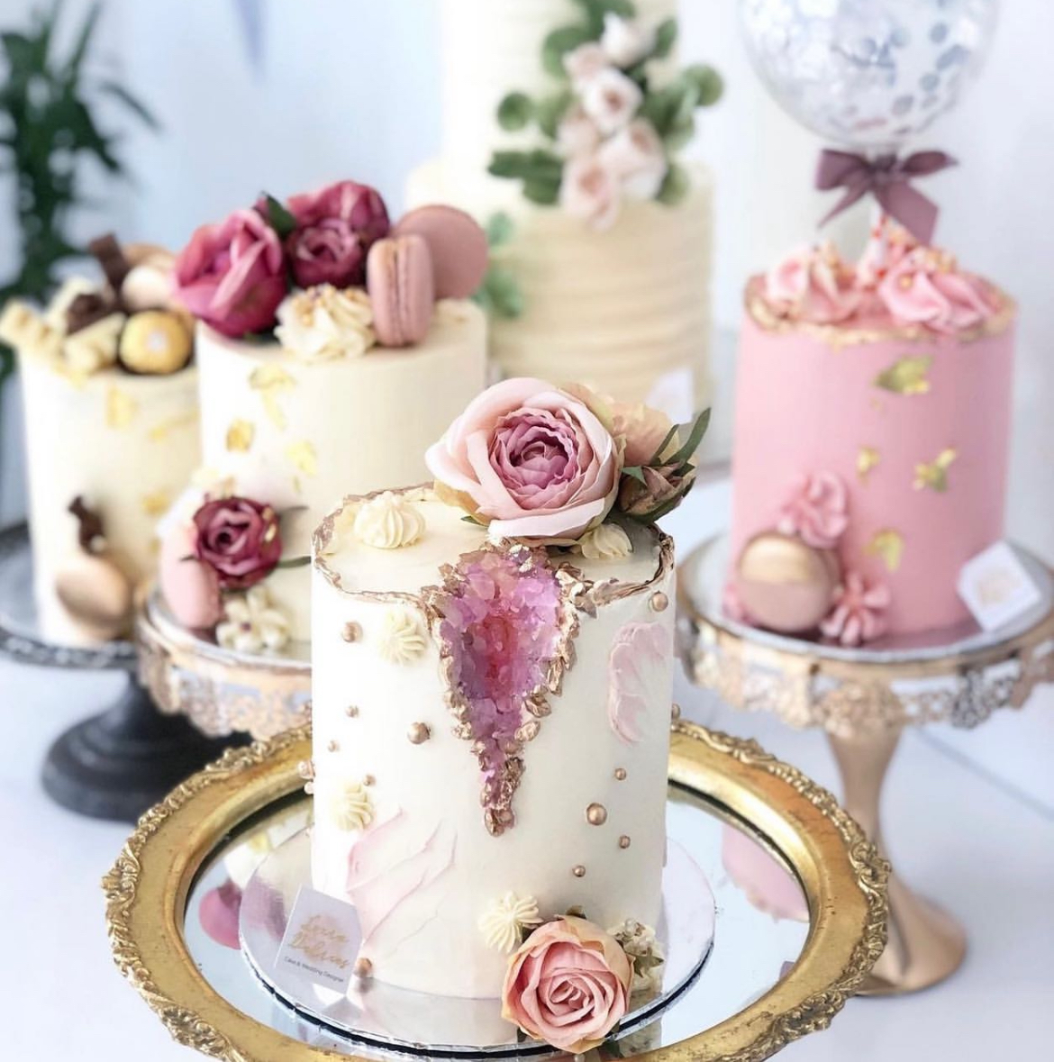 Collection of bespoke wedding cakes with handcrafted sugar flowers, macarons and gold detailing